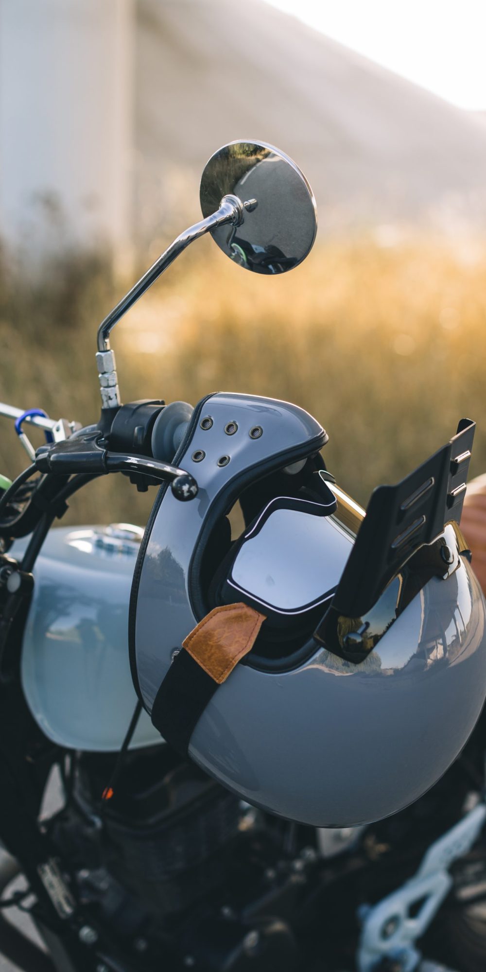 motorcycle white helmet with goggle hanged in a handle bar